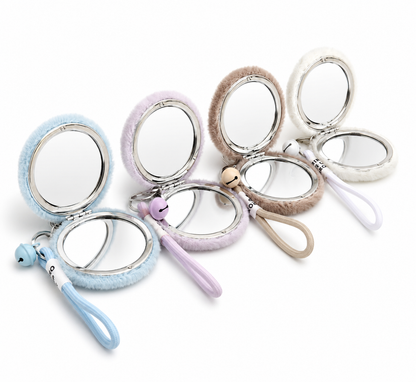 Plush faux-fur mirror keychain shown open revealing dual-sided magnifying mirror inside — MOUJ Egypt